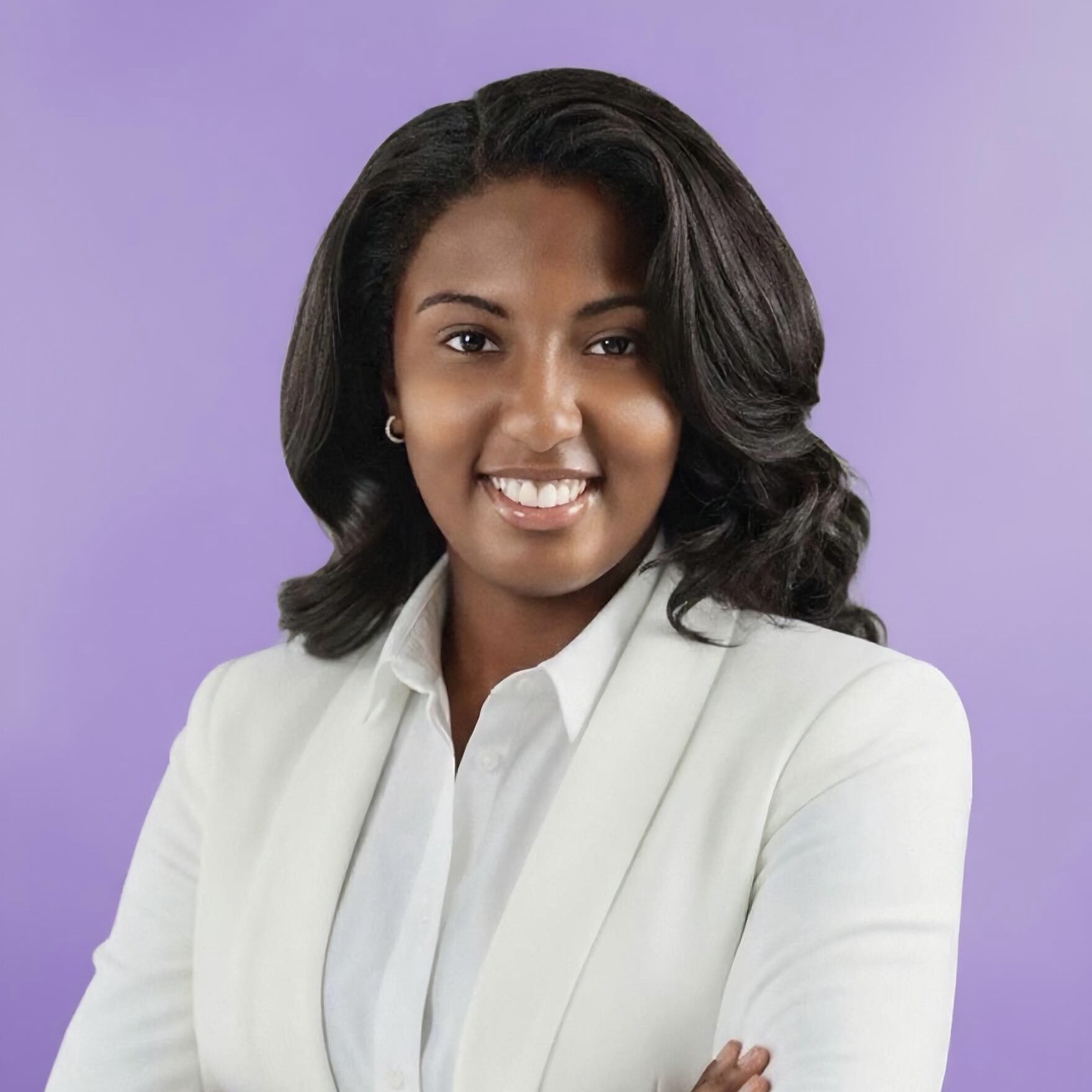 Woman with shoulder length hair in a white shirt and blazer